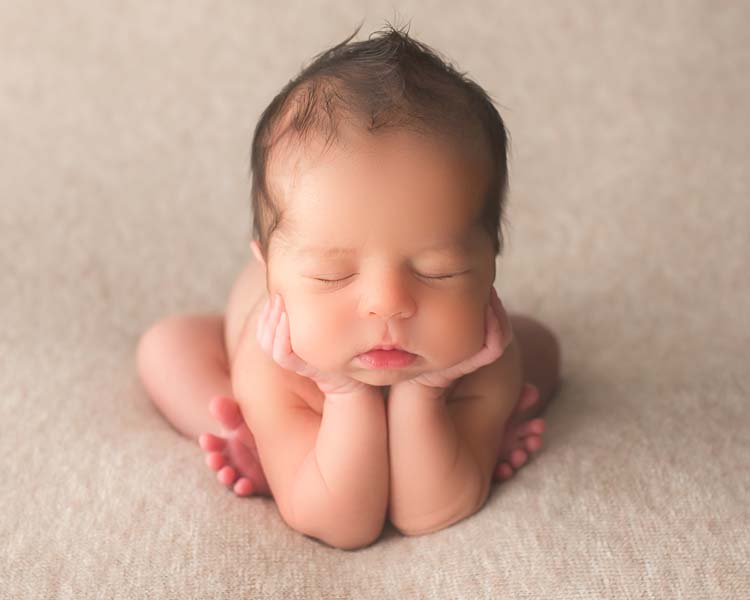 Newborn Baby Boy posed on light brown fabric. Froggy Pose